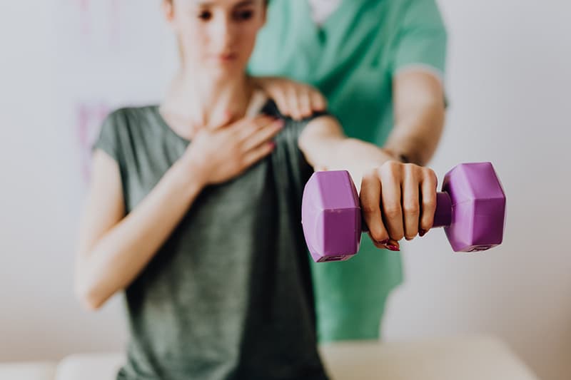 woman using dumbbells for sports injury