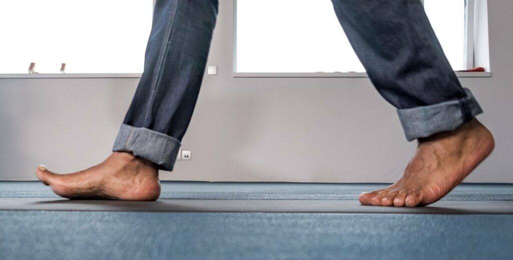 Close-up of bare feet walking during a movement assessment using Footscan technology.